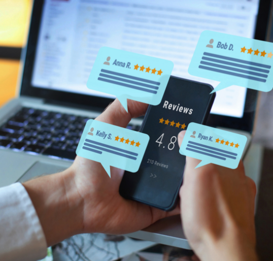 hands holding mobile phone over a laptop with speech bubbles